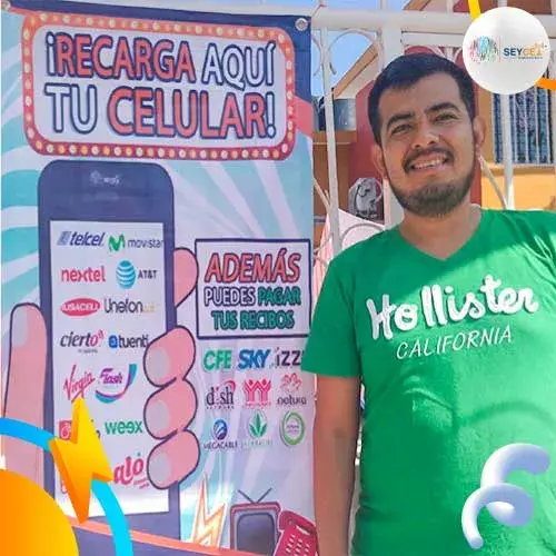 hombre frente a lona con informacion para vender recargas desde su casa
