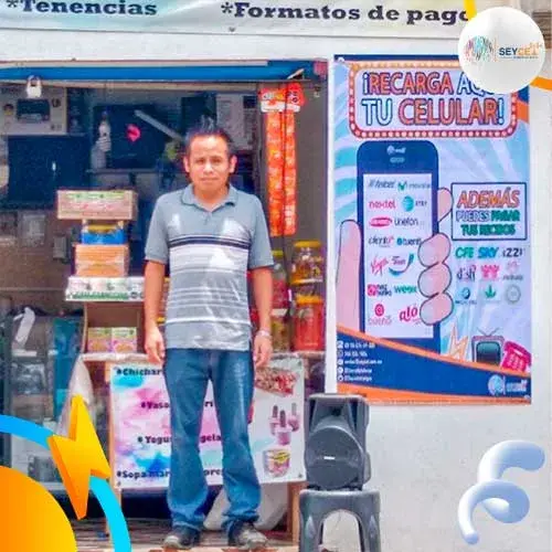 dueño de cafe internet afuera de su negocio vendiendo recargas